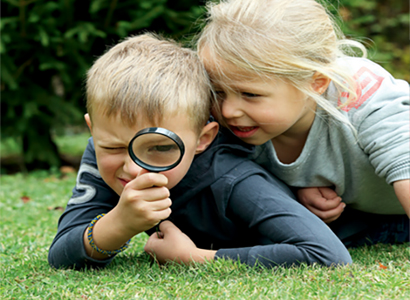 2 enfants scrutent l'herbe